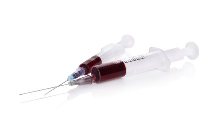 Plastic syringes with blood on white background