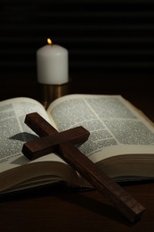 Photo of Cross, Bible and church candle on wooden table