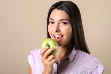 Photo of Young woman with healthy teeth and apple on color background
