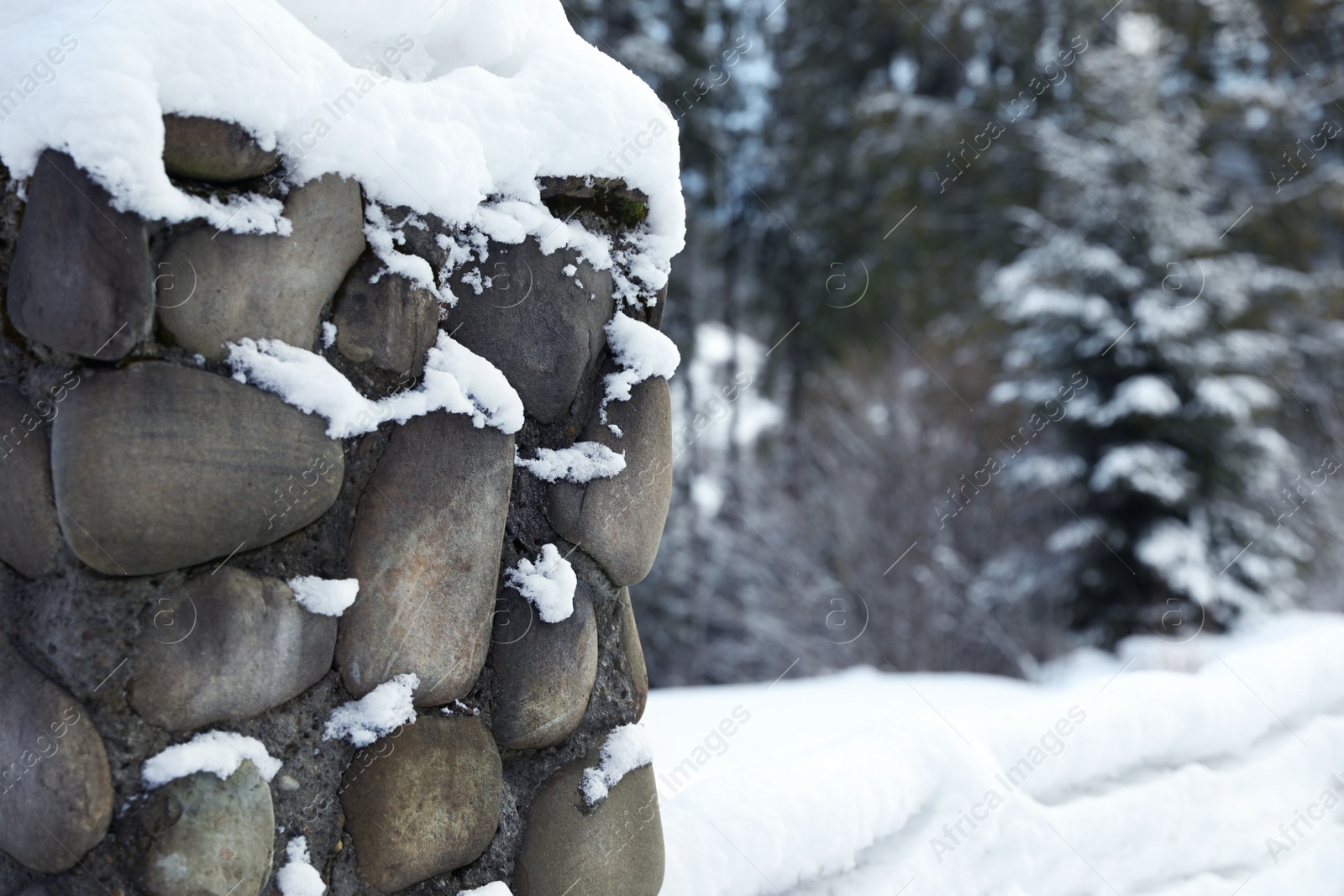 Photo of Snowy stone wall outdoors on winter day, closeup