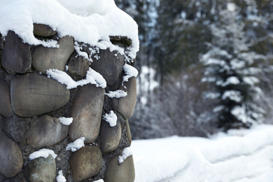 Snowy stone wall outdoors on winter day, closeup