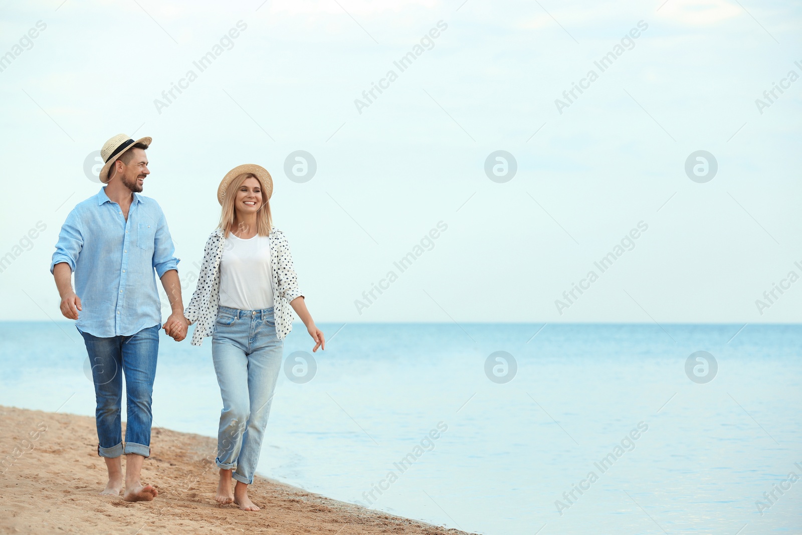 Photo of Happy romantic couple walking on beach, space for text