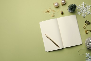Open notebook, stationery and festive decor on light green background, flat lay with space for text. New Year aims