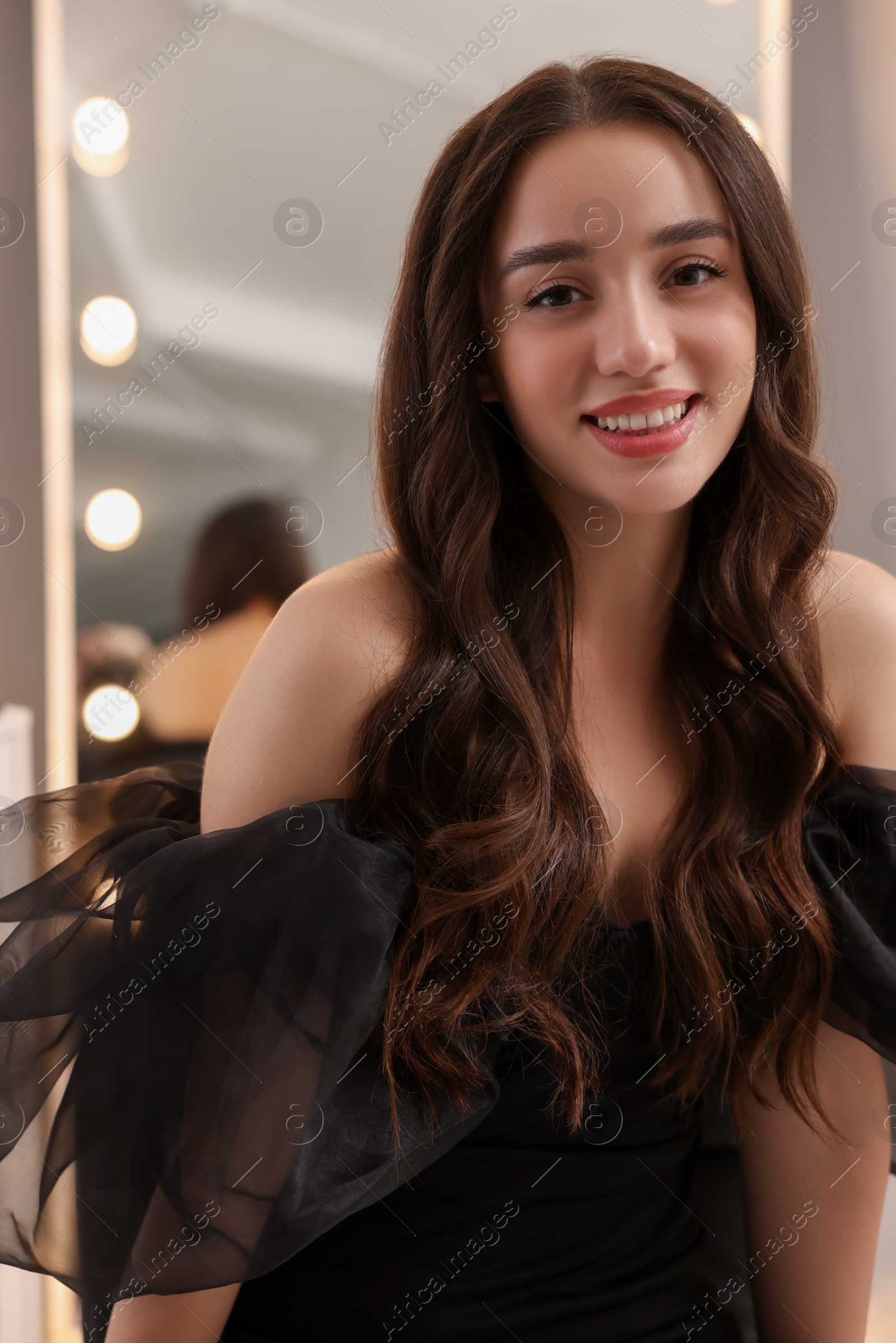 Photo of Portrait of smiling woman with curly hair indoors