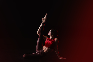 Young woman performing acrobatic element on stage indoors