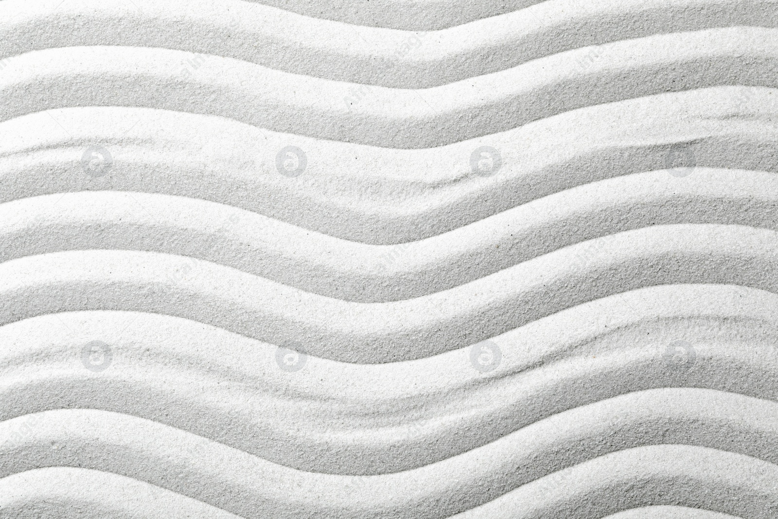 Photo of Zen garden pattern on sand as background, top view. Meditation and harmony