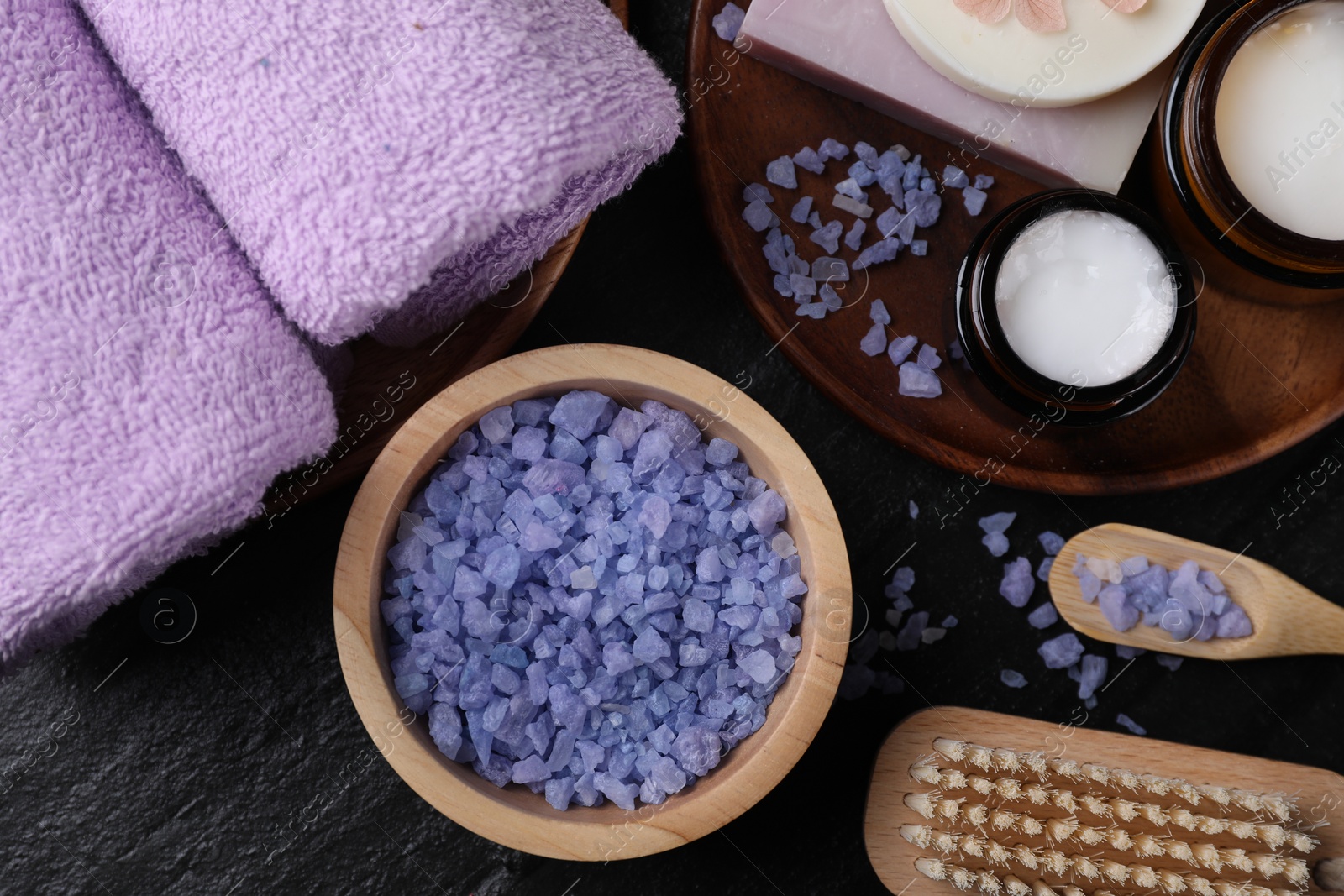 Photo of Flat lay composition with different spa products and lavender on black textured table