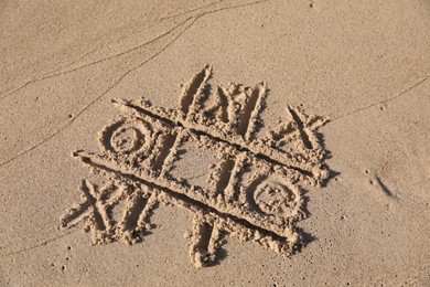 Photo of Tic tac toe game drawn on sandy beach, above view