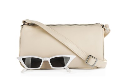 Photo of Women's leather bag and sunglasses on white background