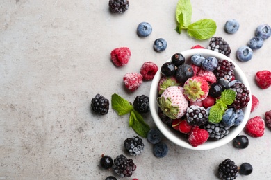 Photo of Mix of different frozen berries on grey table, flat lay. Space for text
