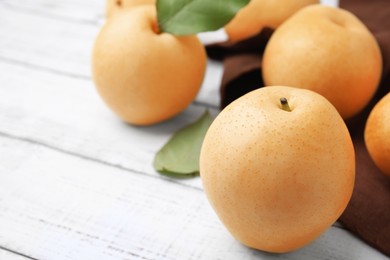 Delicious apple pears on white wooden table, closeup. Space for text