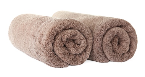 Photo of Rolled clean brown towels on white background