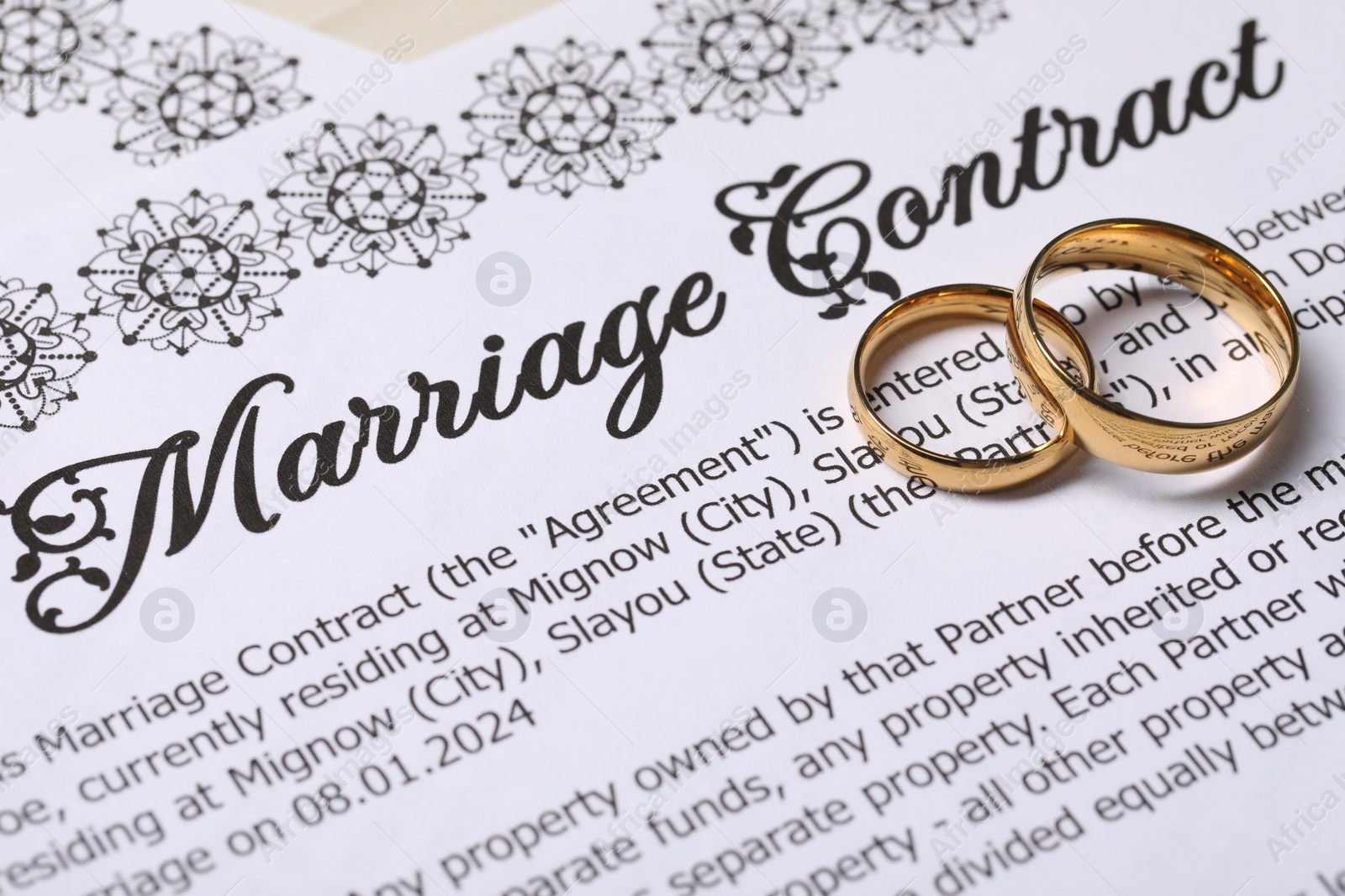 Photo of Marriage contracts and gold rings on table, closeup