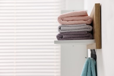 Photo of Fresh towels and toiletries on shelf indoors. Space for text