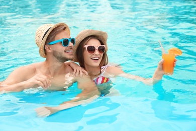 Young couple in pool on sunny day