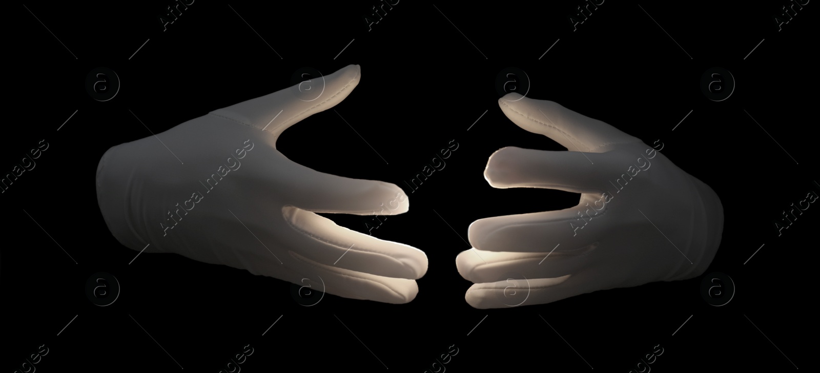 Photo of Magician holding something on black background, closeup