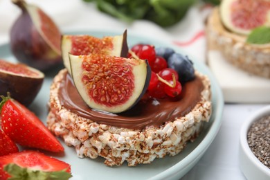 Photo of Tasty crispbreads with chocolate, figs and sweet berries on plate, closeup