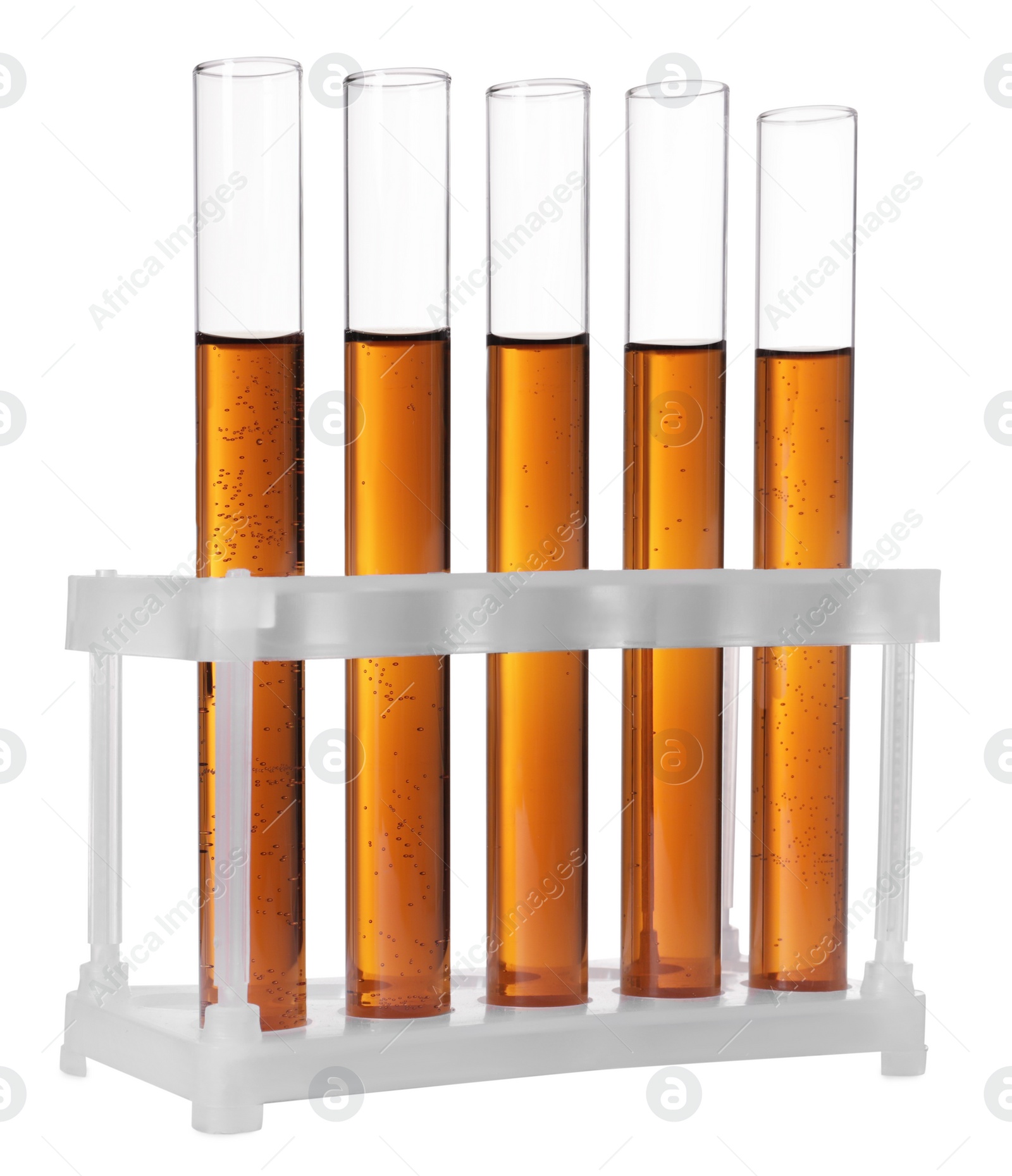 Photo of Test tubes with brown liquid in stand on white background