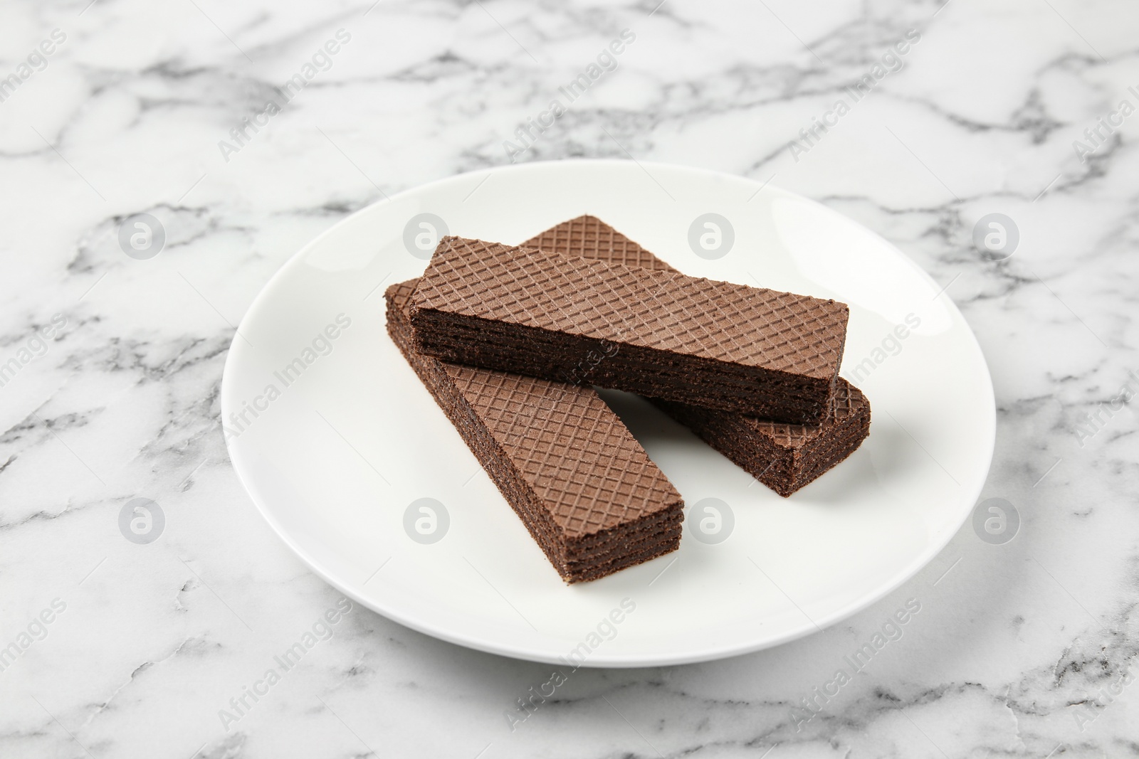 Photo of Plate of delicious chocolate wafers on marble background