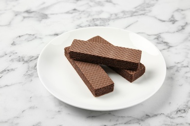 Plate of delicious chocolate wafers on marble background