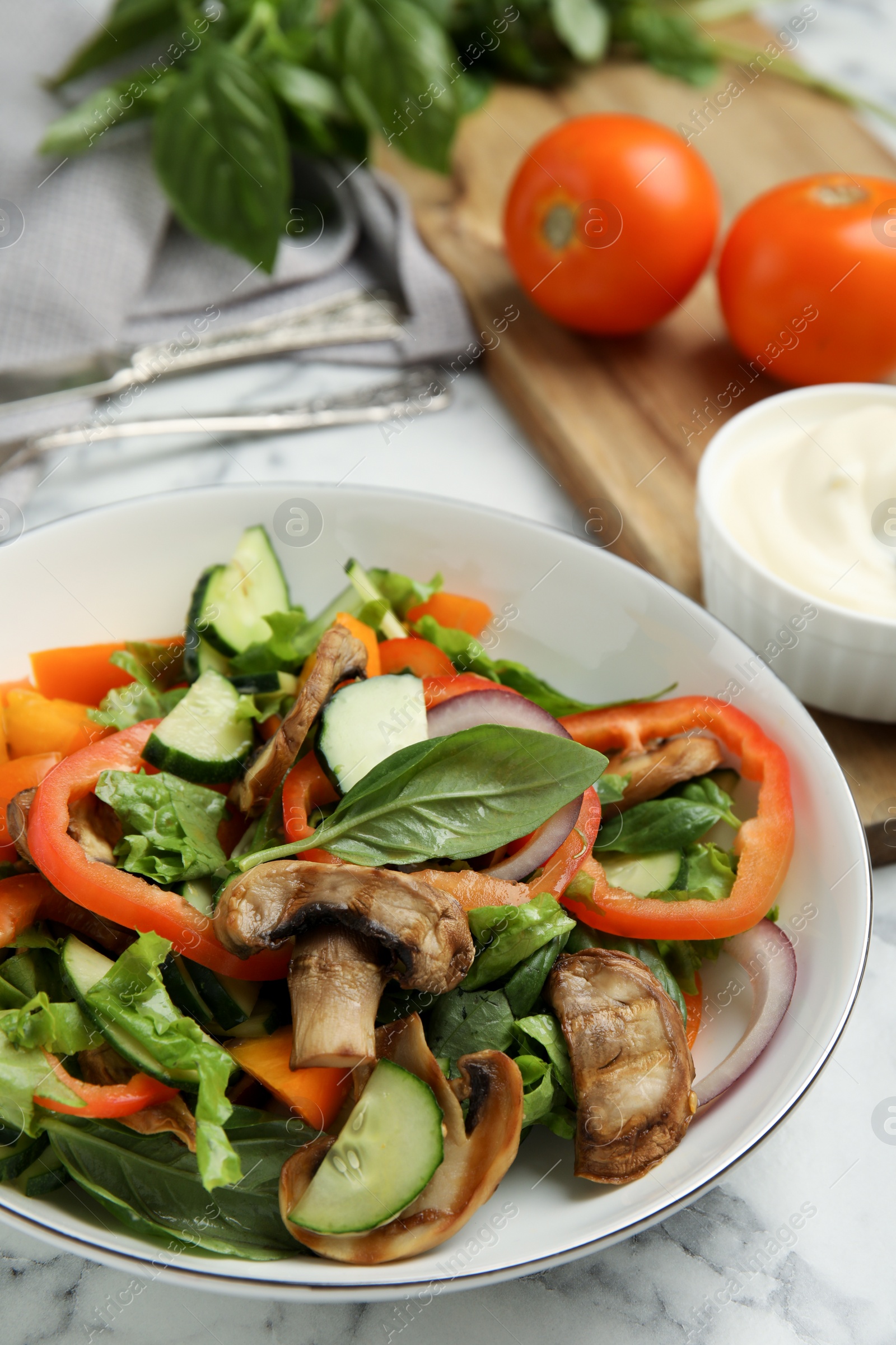 Photo of Bowl of delicious salad on white marble table, closeup