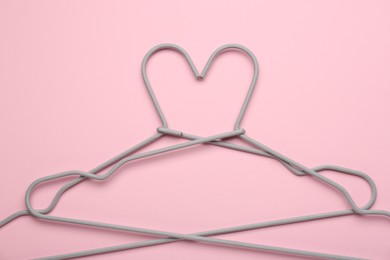 Two hangers on pink background, top view