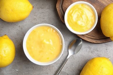 Delicious lemon curd in bowl on grey table, flat lay