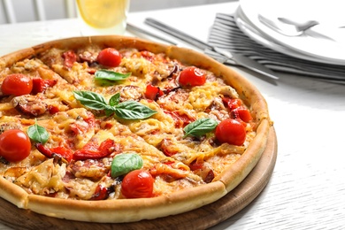 Delicious pizza with tomatoes and sausages on table