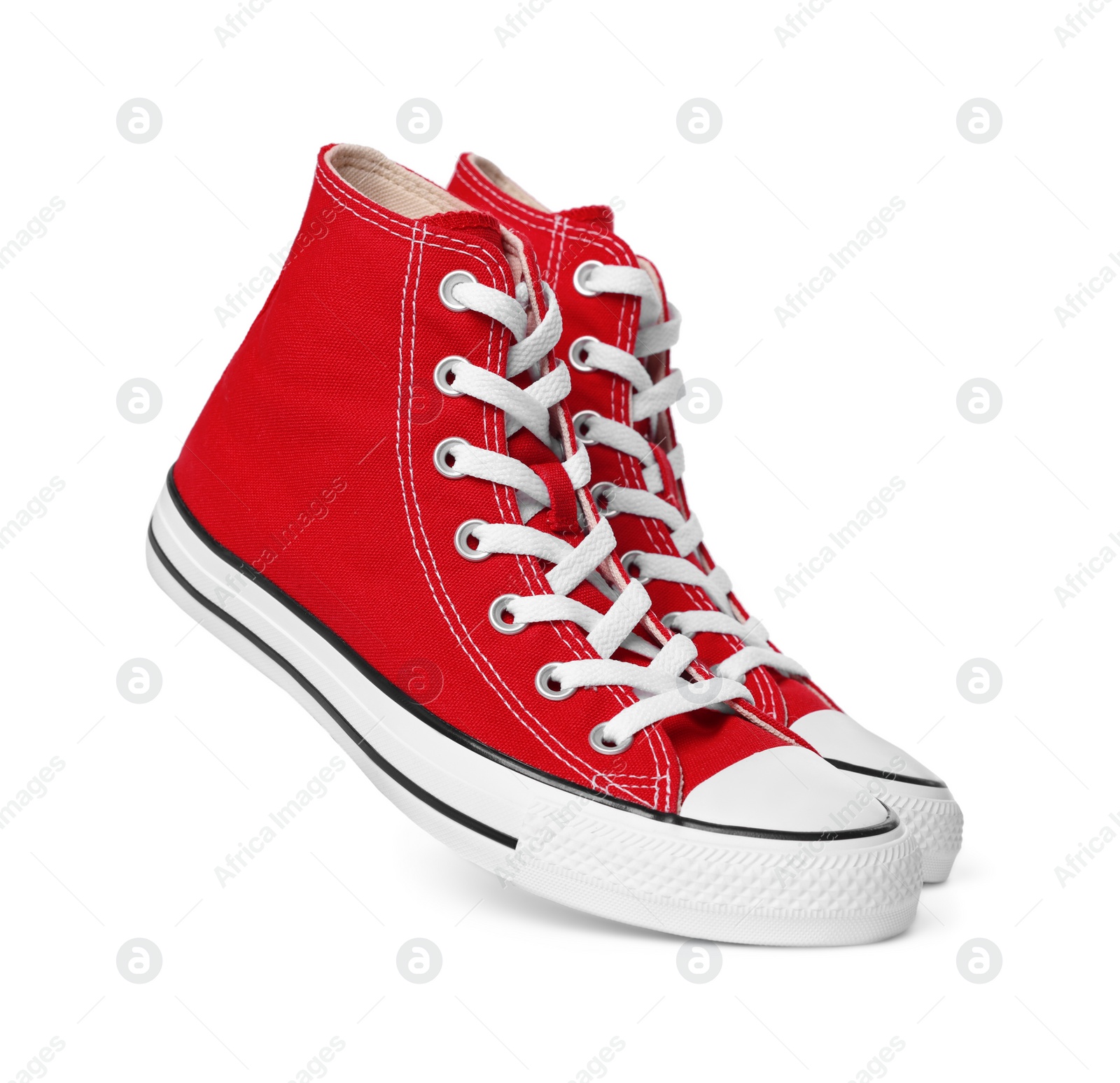 Photo of Pair of new red stylish high top plimsolls on white background