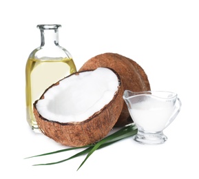 Photo of Composition with bottle of natural organic oil, ripe coconuts and milk isolated on white