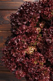 Fresh red coral lettuce on wooden table, top view