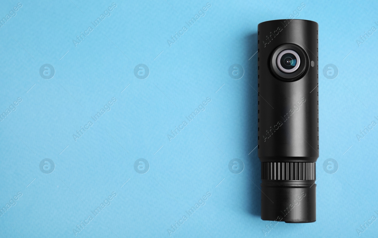 Photo of Black modern car camera on turquoise background, top view. Space for text