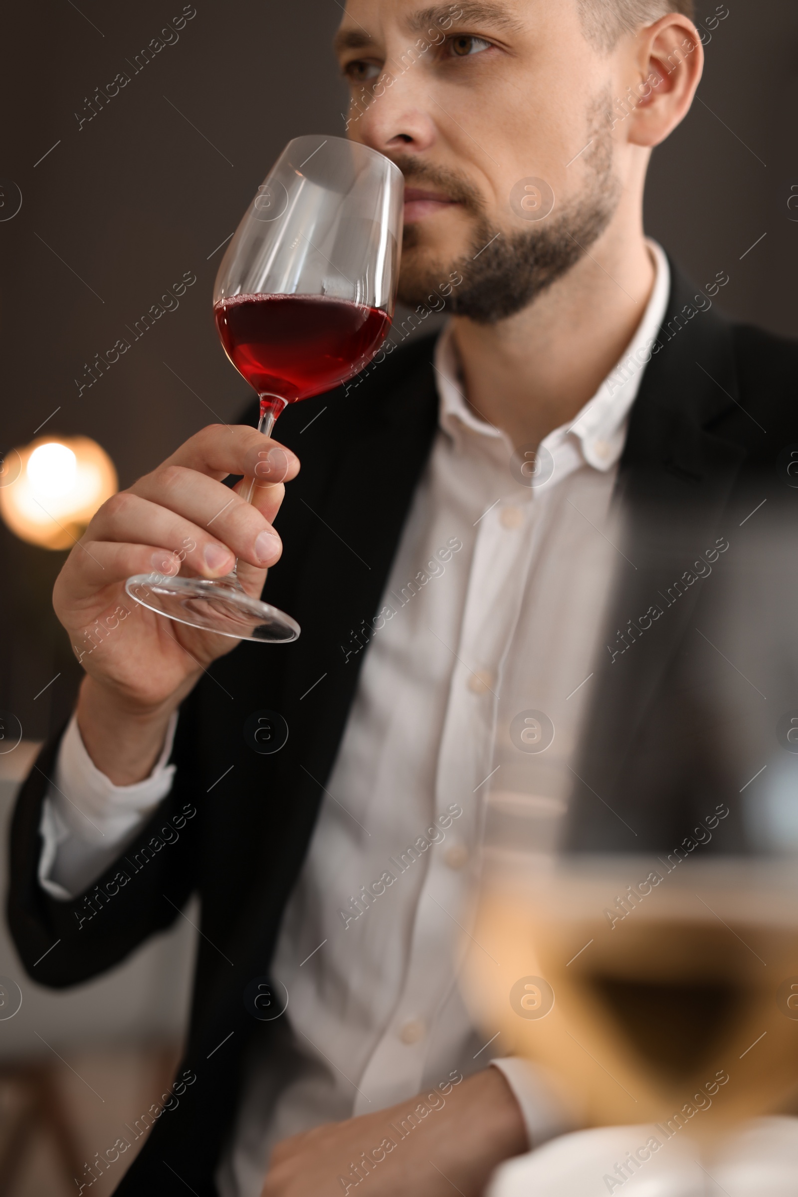 Photo of Young man with glass of wine indoors