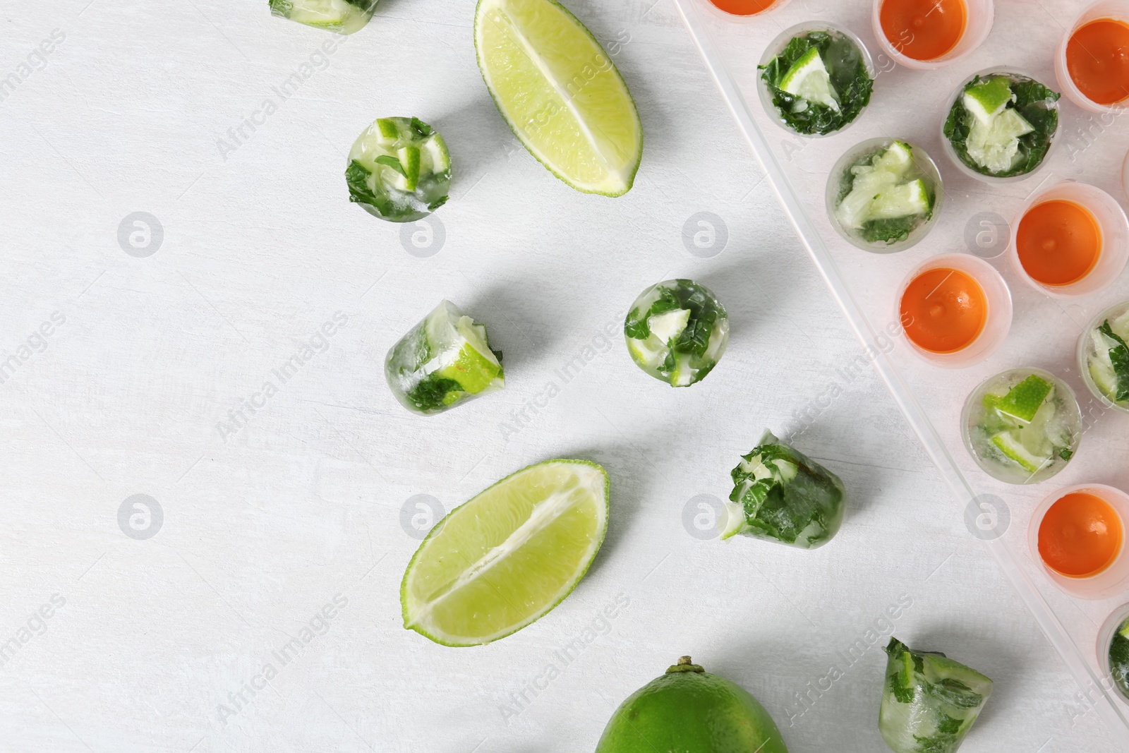 Photo of Composition with lime and mint ice cubes on light background, flat lay