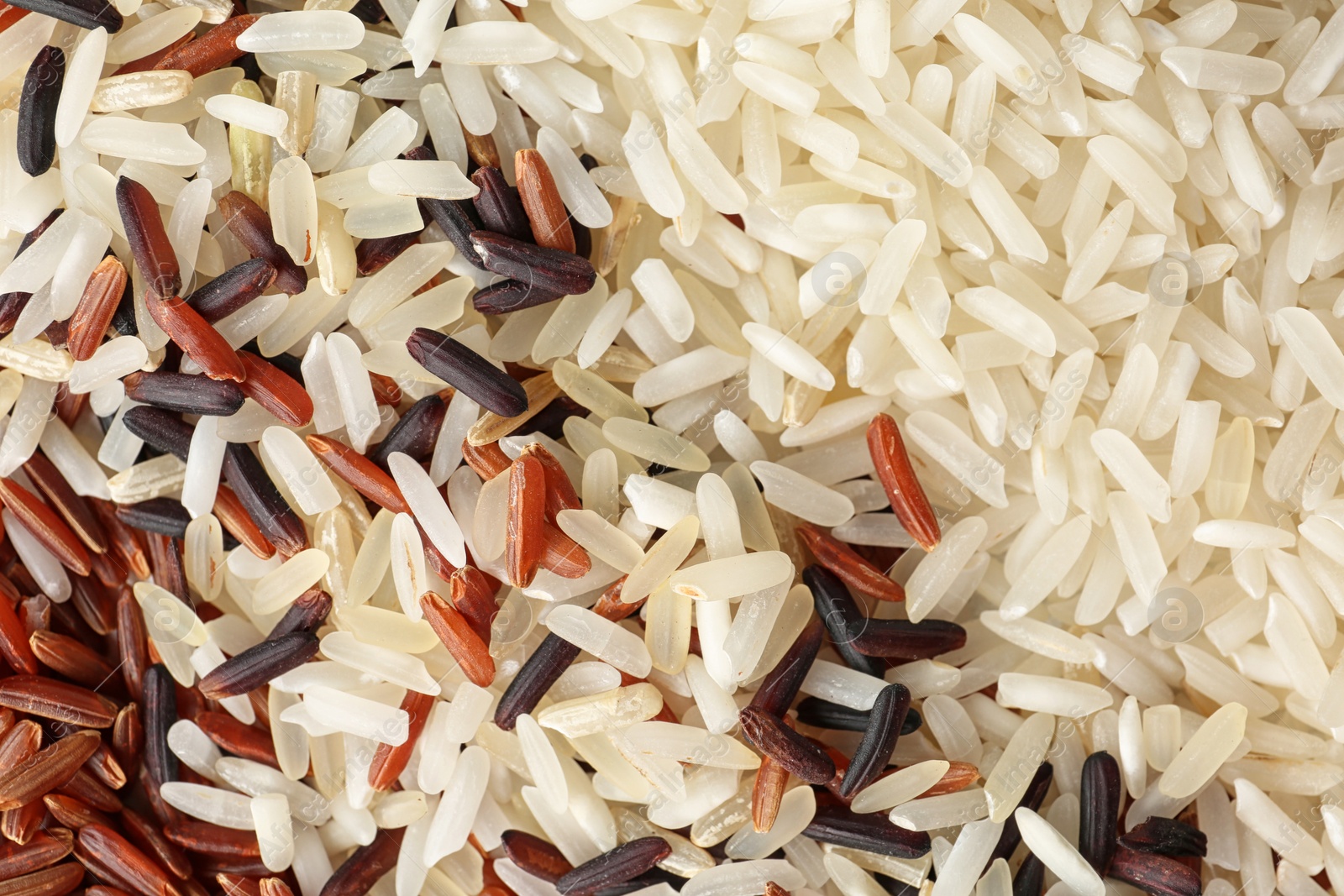 Photo of Brown and other types of rice as background, closeup