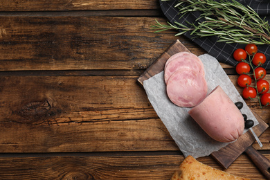 Flat lay composition with tasty ham on wooden table. Space for text