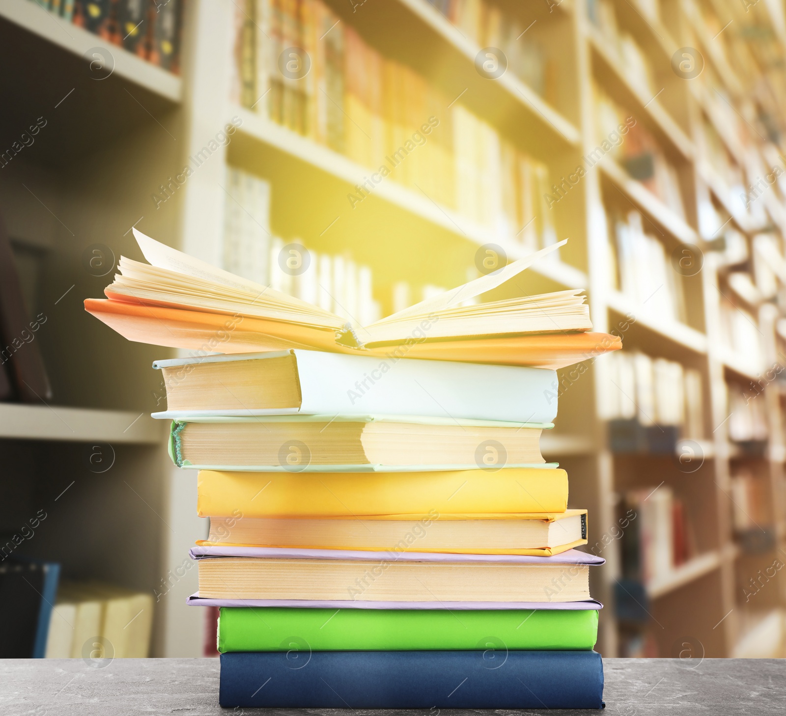 Image of Stack of colorful books on table in library 