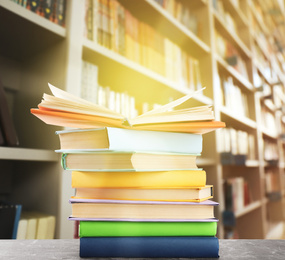 Image of Stack of colorful books on table in library 