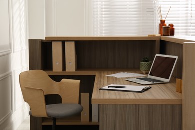 Photo of Receptionist's workplace with laptop in hotel. Interior design