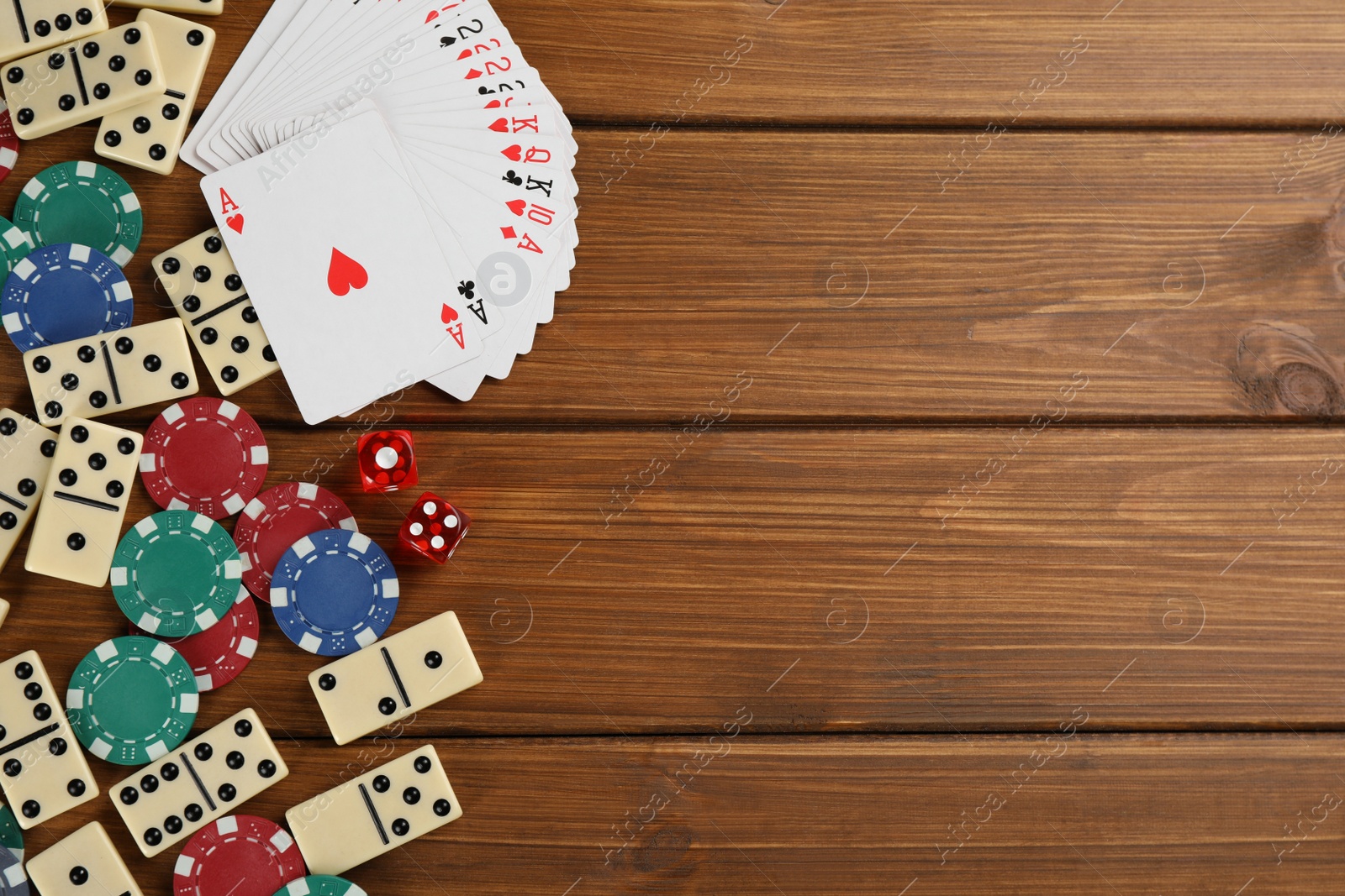 Photo of Elements of different board games on wooden table, flat lay. Space for text