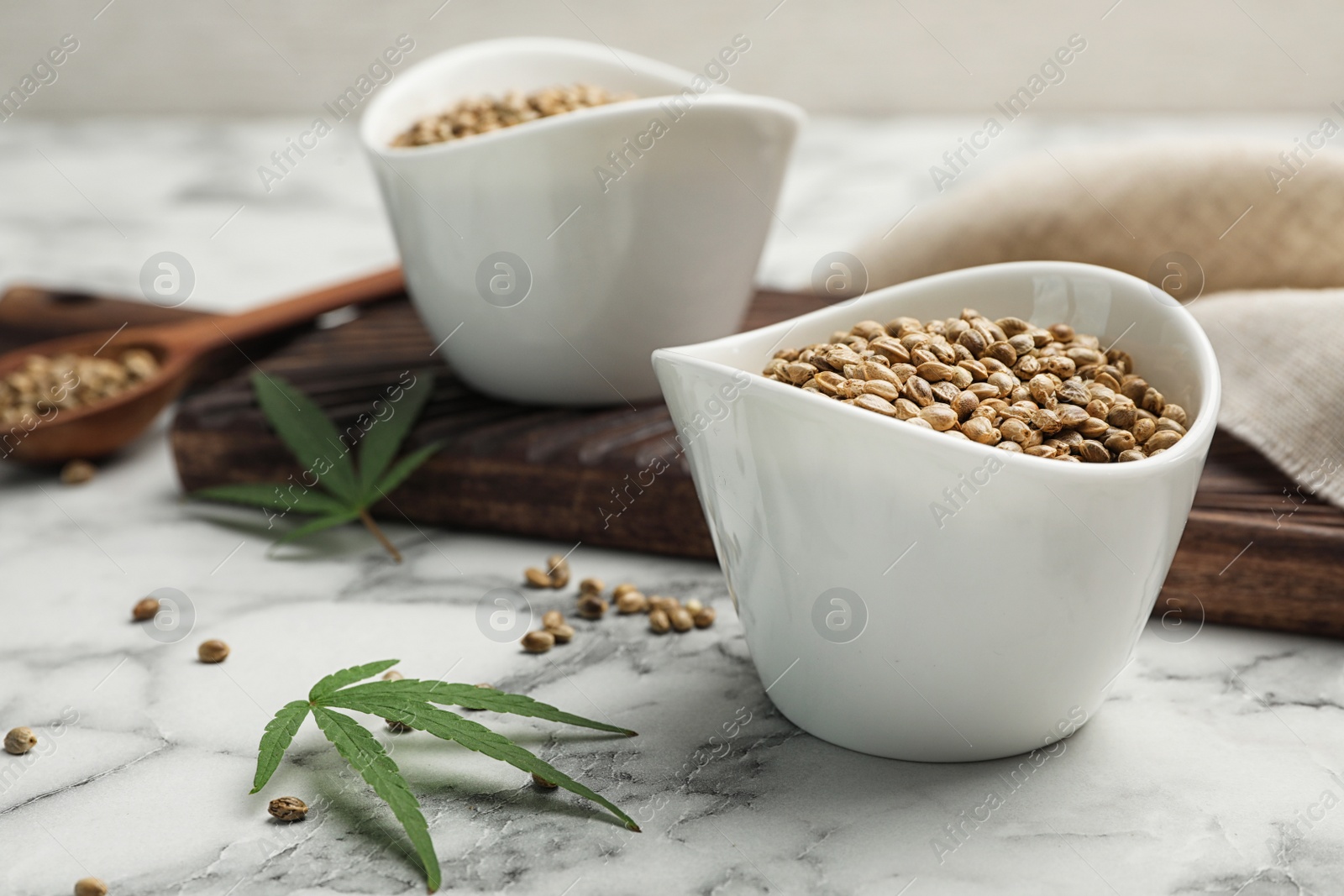 Photo of Organic hemp seeds in bowl on marble table