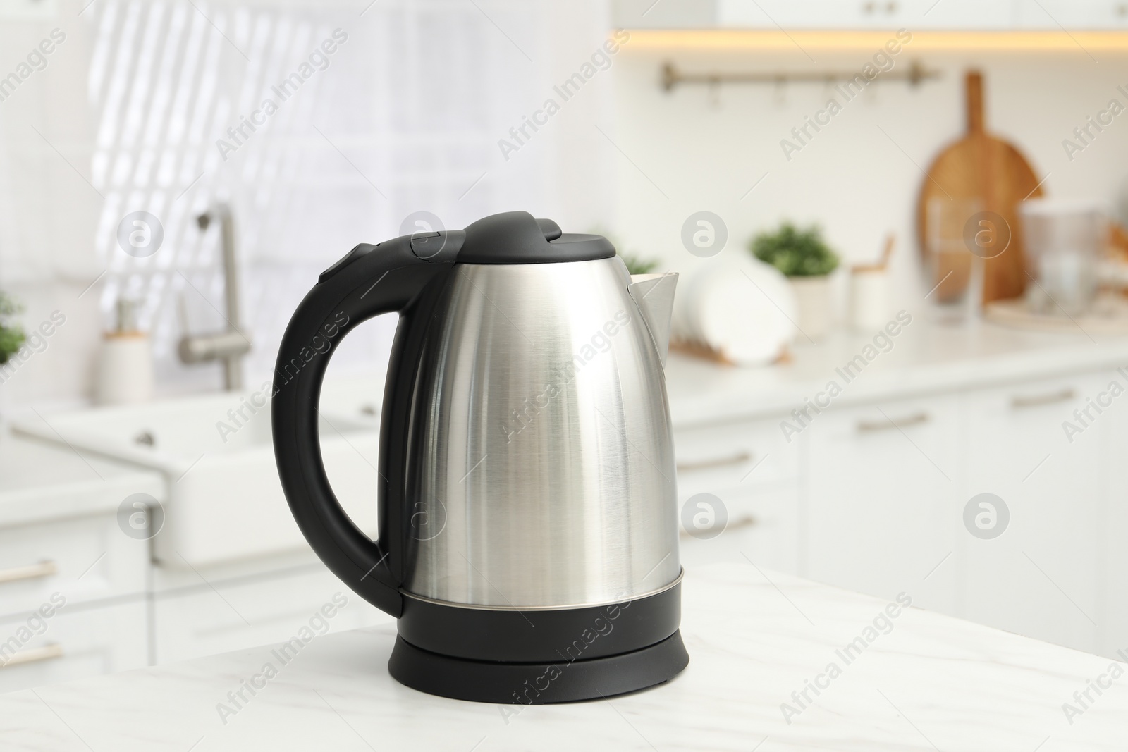 Photo of Modern electric kettle on table in kitchen