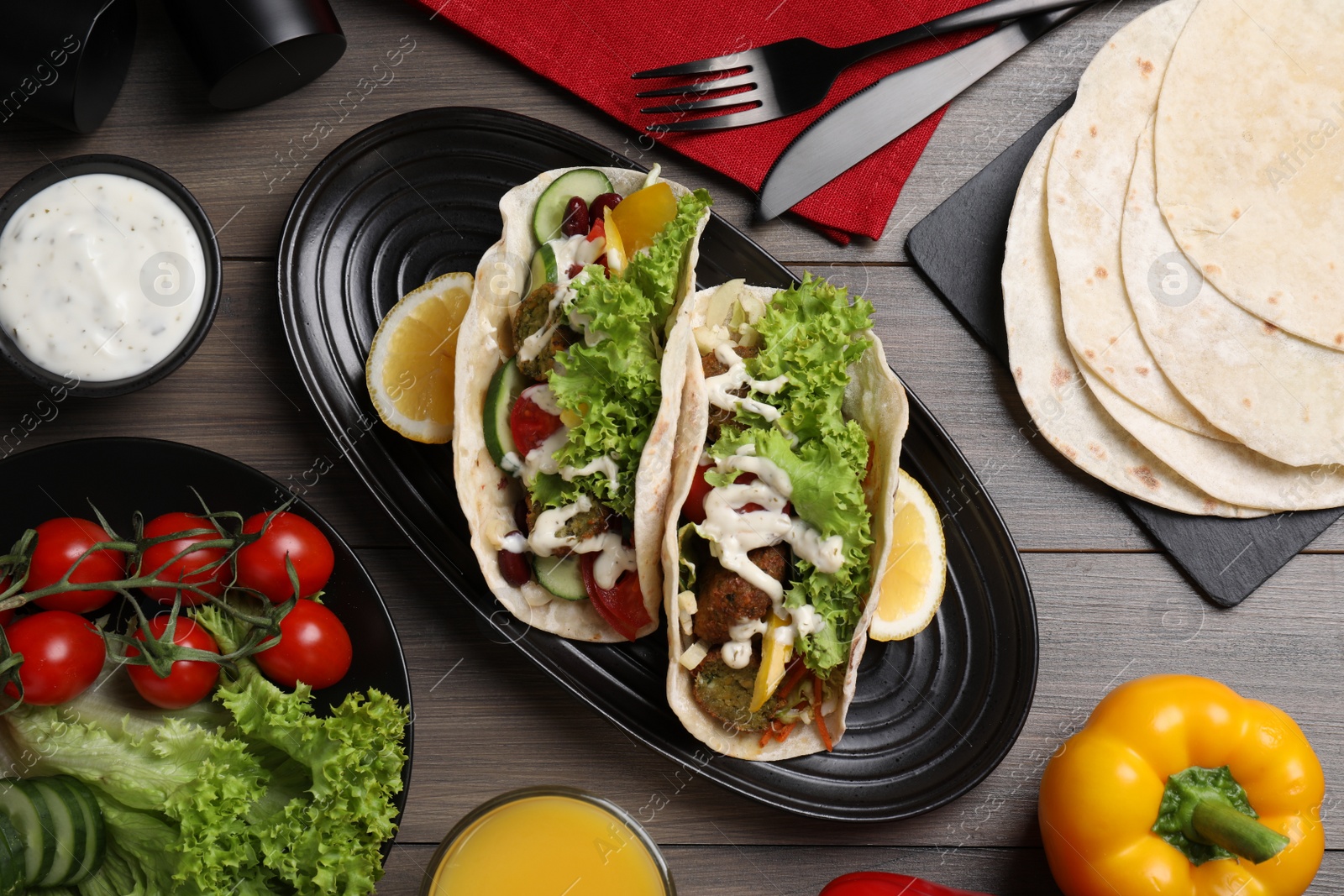 Photo of Delicious fresh vegan tacos served on wooden table, flat lay