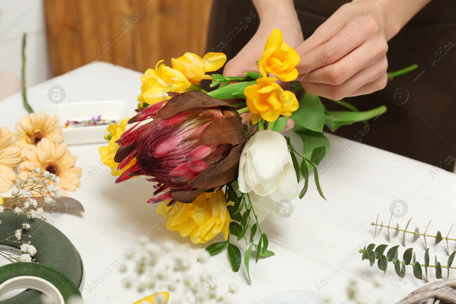 Photo of Female florist making beautiful bouquet at table