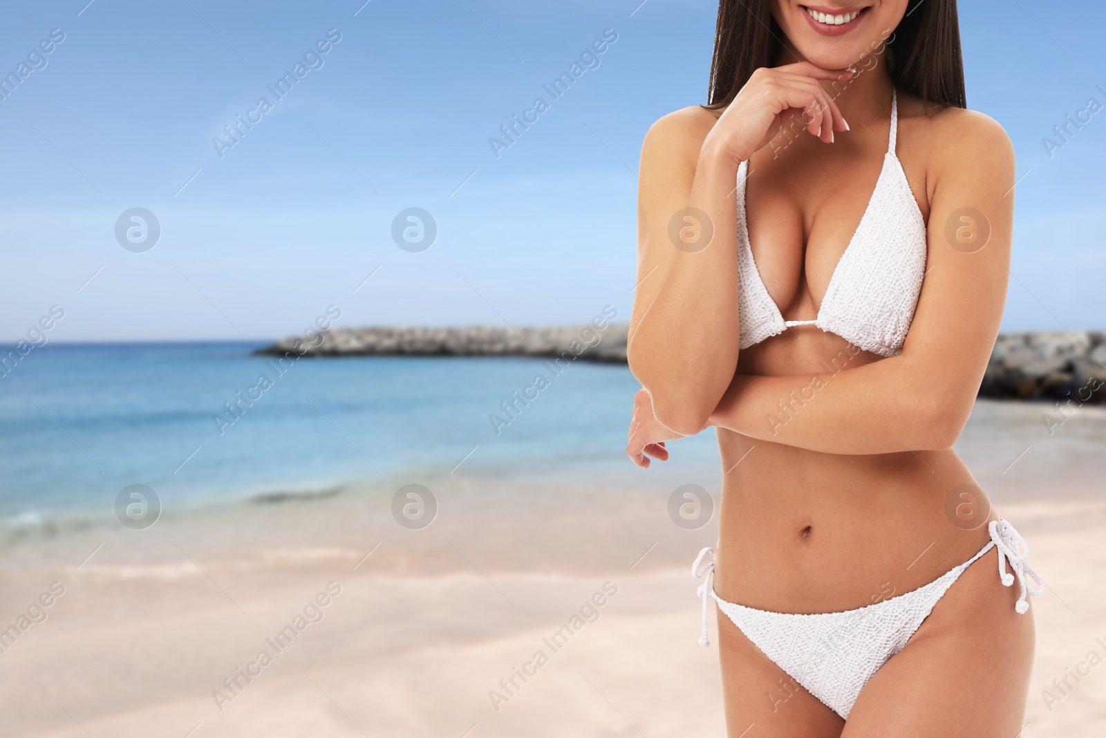 Image of Pretty sexy woman with slim body in stylish bikini at beach, closeup. Space for text