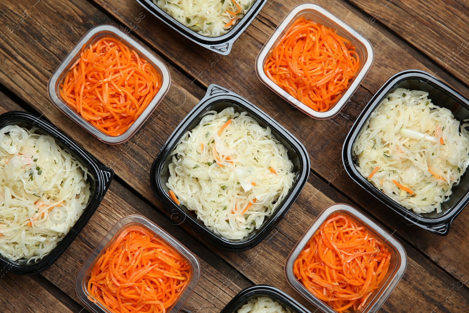 Photo of Plastic containers with tasty vegetable salads on wooden table, flat lay. Food delivery service