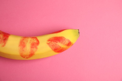 Photo of Top view of fresh banana with red lipstick marks on pink background, space for text. Oral sex concept