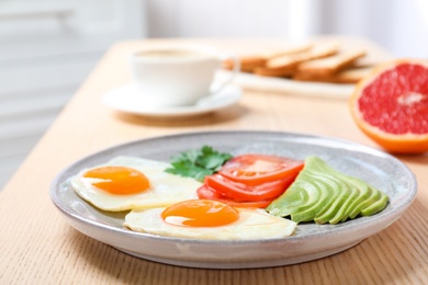 Photo of Plate with fried eggs and vegetables on wooden table. Healthy breakfast