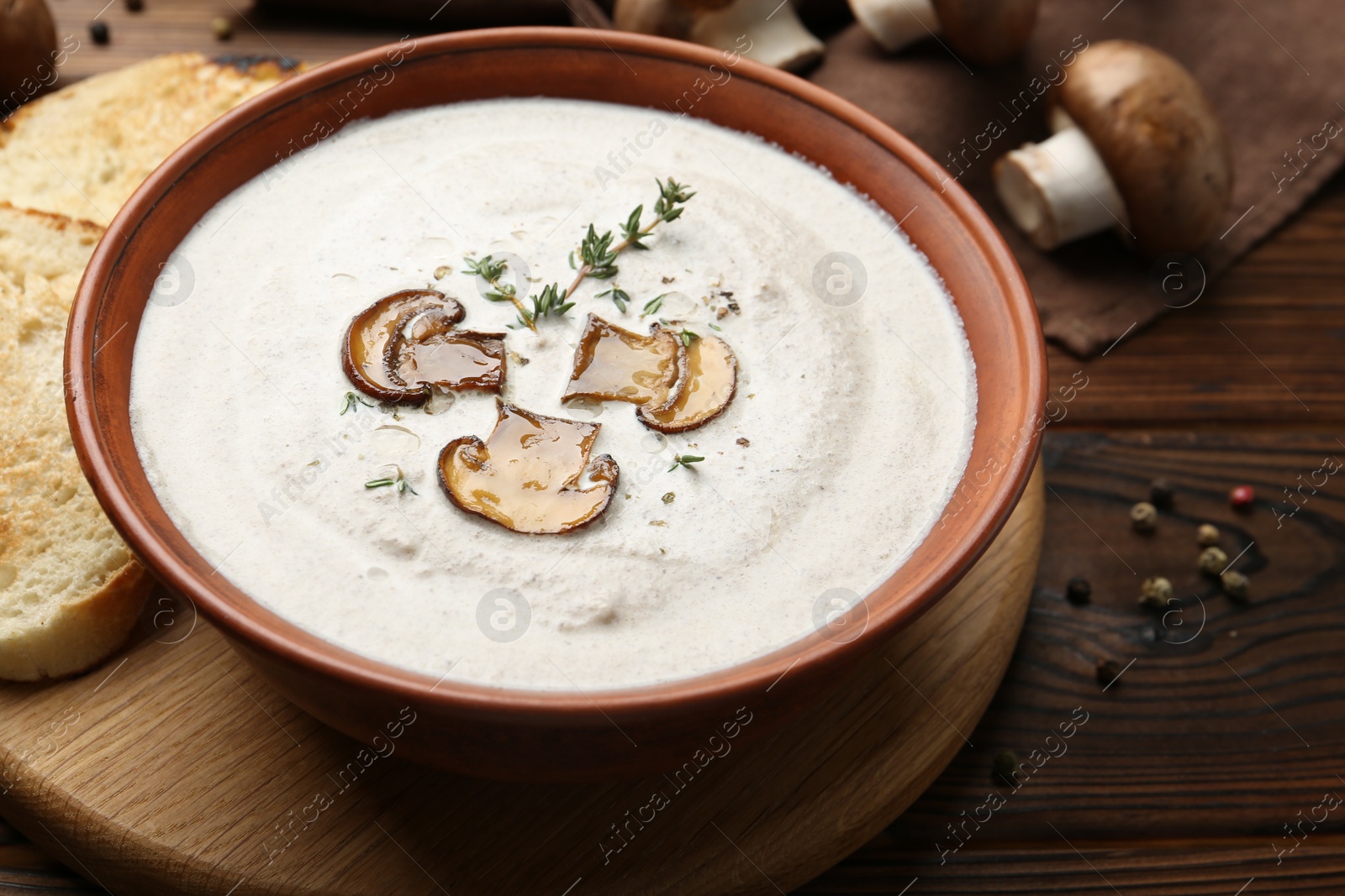 Photo of Fresh homemade mushroom soup in ceramic bowl on wooden table