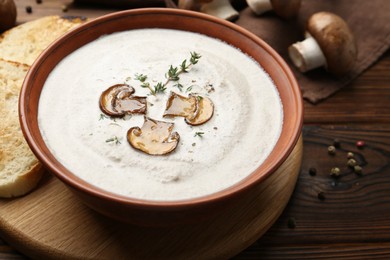 Photo of Fresh homemade mushroom soup in ceramic bowl on wooden table